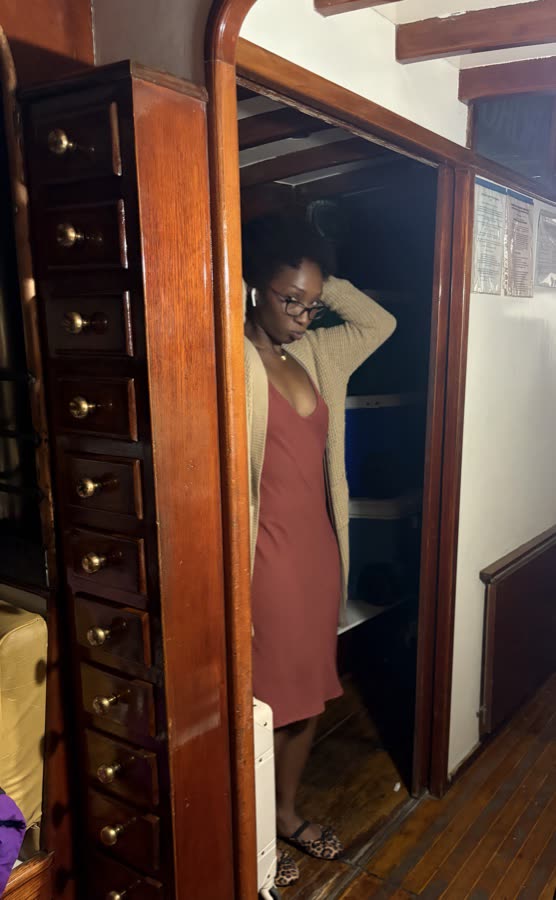 Destiny below deck aboard JADA, framed by the yawl's mahogany cabinetry