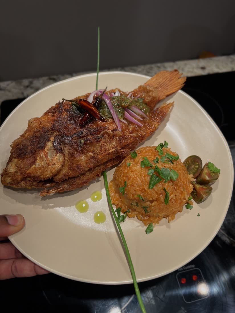 Whole fried snapper with green nam jim, dried chilies, and a mound of jollof rice
